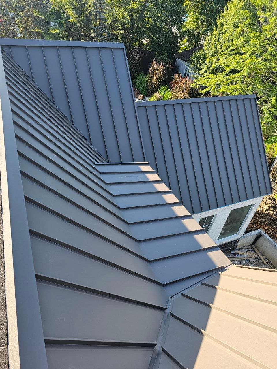 Aerial view of grey standing seam roof detail — VAH Construction