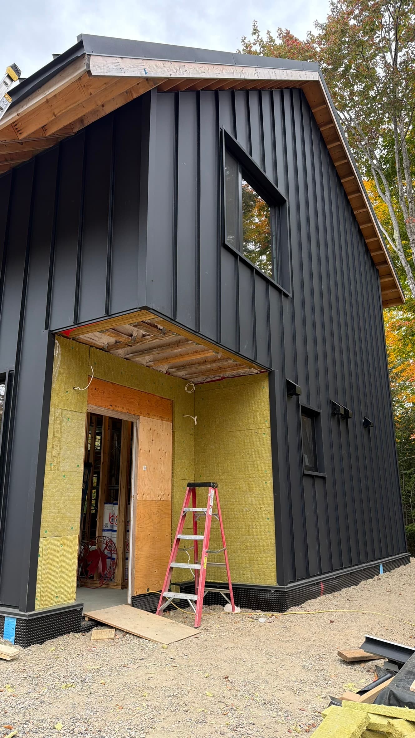 Black vertical metal siding on a modern barn-style gable wall — VAH Construction