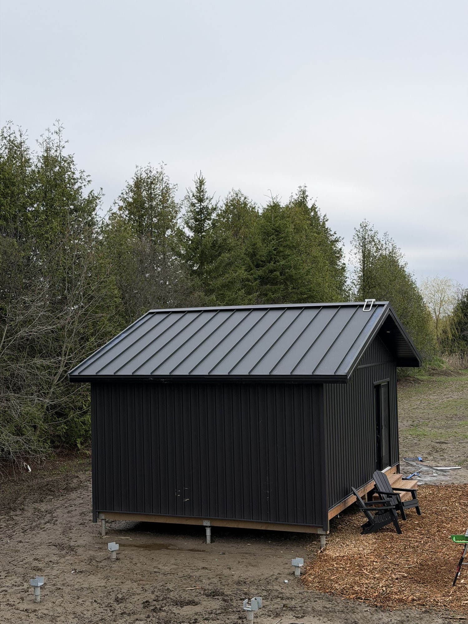 Black metal roof and siding on garden studio — VAH Construction